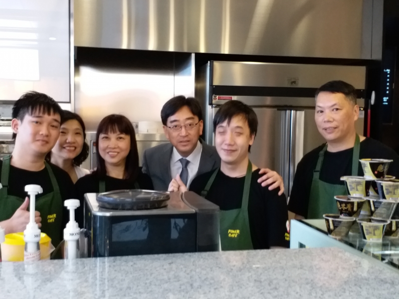 食物及衛生局局長高永文醫生和視障咖啡師啊輝及活力咖啡店員工合照。