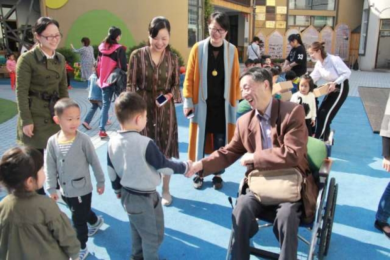 余绍森在幼儿园与孩子们握手