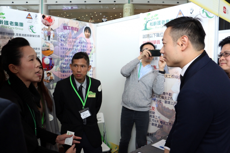 勞工及福利局副局長徐英偉先生（右）與參與招聘會的僱主代表交換意見。