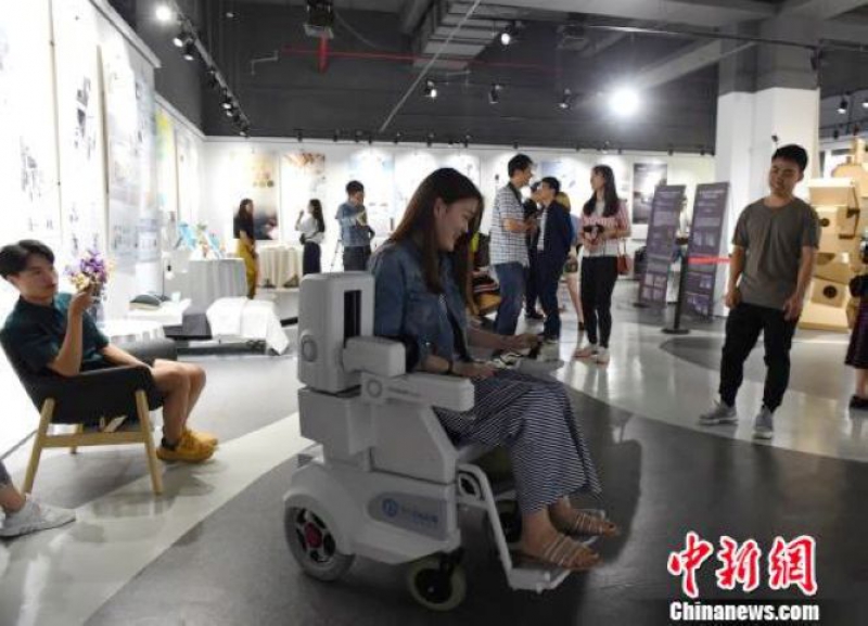 圖為重慶大學生設計的新型康復輪椅吸引市民體驗