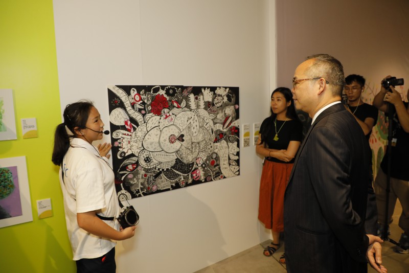 香港紅十字會甘迺迪中心同學正在向劉江華局長介紹畫作