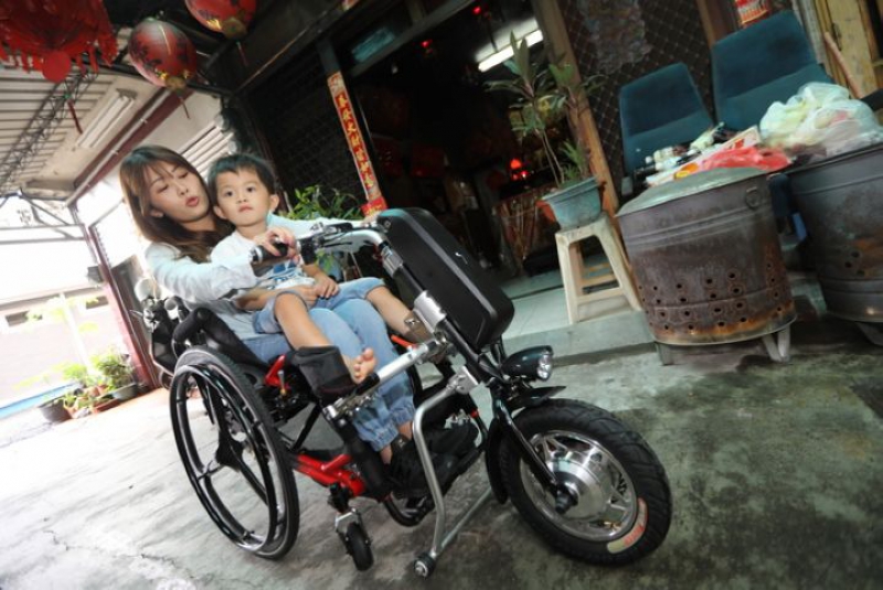 輪椅加上電動車頭，姿予帶小外甥去兜風