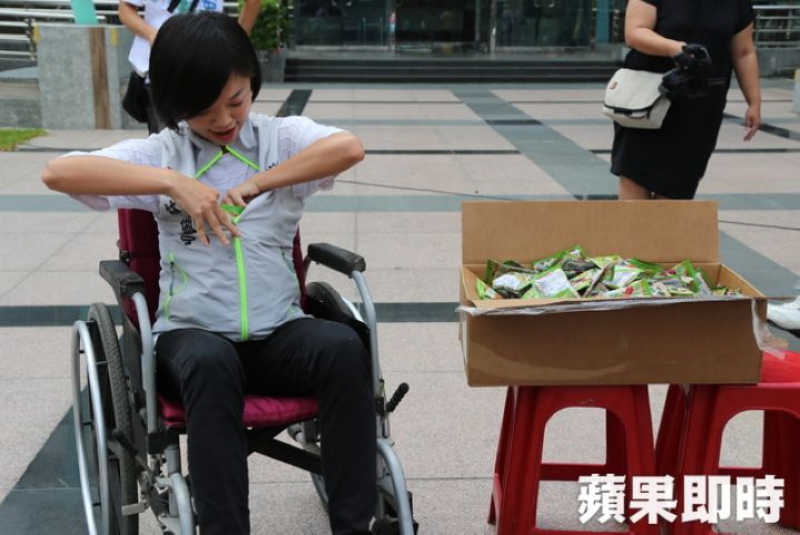 坐在轮椅上的县议员林缃亭拚命的把爆跳弹往背心里面塞，逗得大家哈哈大笑