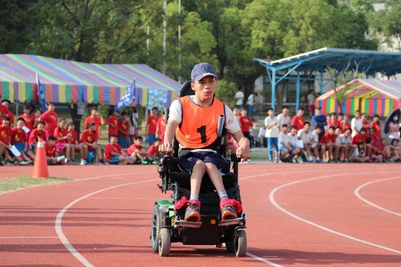 台南永仁高中三年級陳俊仲（中）用輪椅完成人生第一次大隊接力