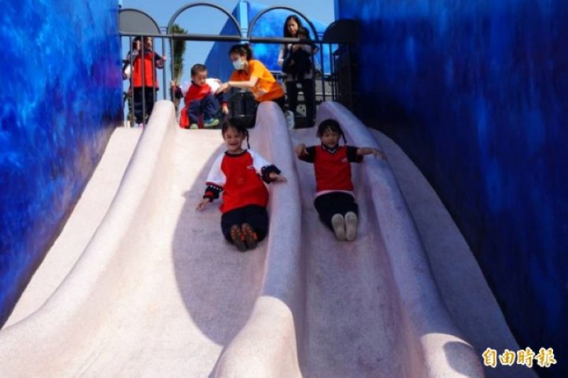 八里商港公園的鯨魚造型地景溜滑梯今天啟用，小朋友玩得不亦樂乎