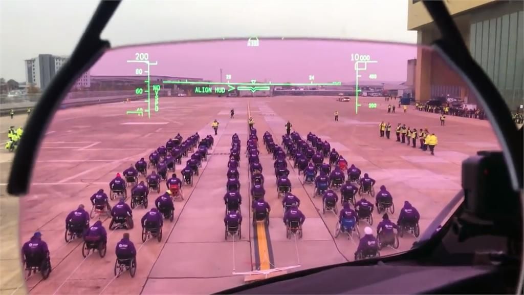 坐轮椅拖飞机 近百位残疾人士写世界纪录