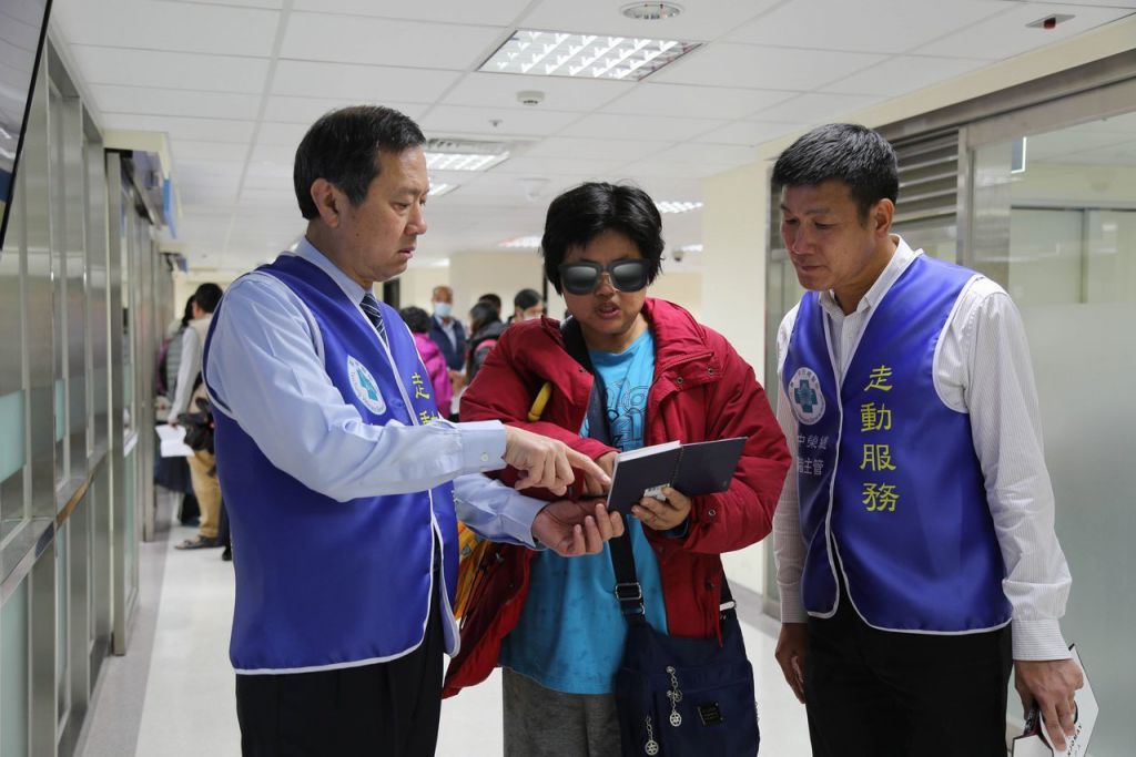 台中榮總院長許惠恒（左）在院內發起「高階主管走動服務」社工室主任莊李和（右）陪他一起為民眾指引