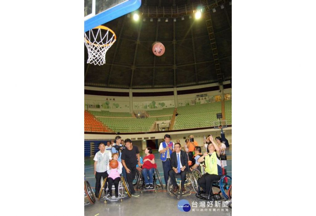 林世贤市长（右）体验坐在轮椅上投篮的困难度