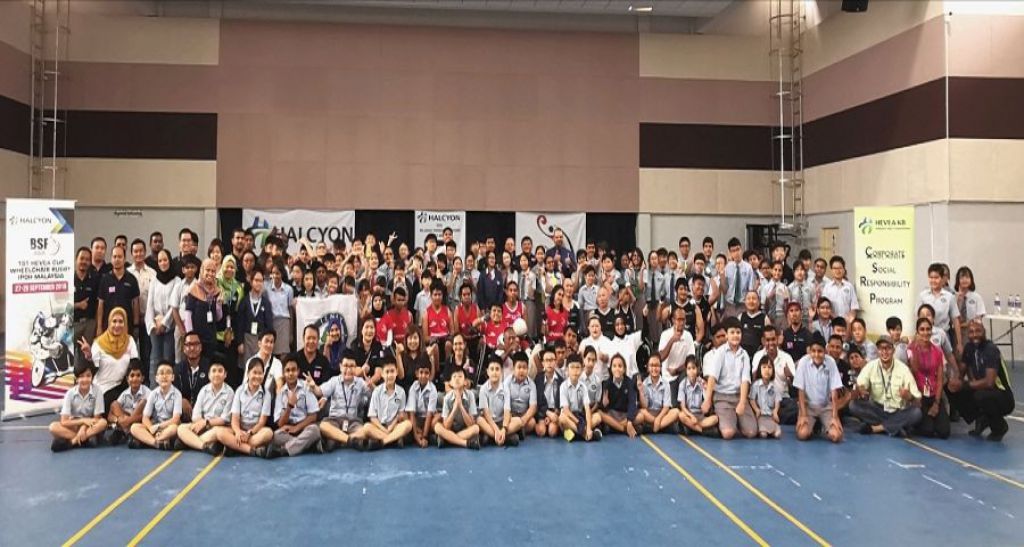 第一屆“三葉膠樹杯”輪椅橄欖球國際賽的參賽者和嘉賓與美露騰比國際學校的師生開心合照