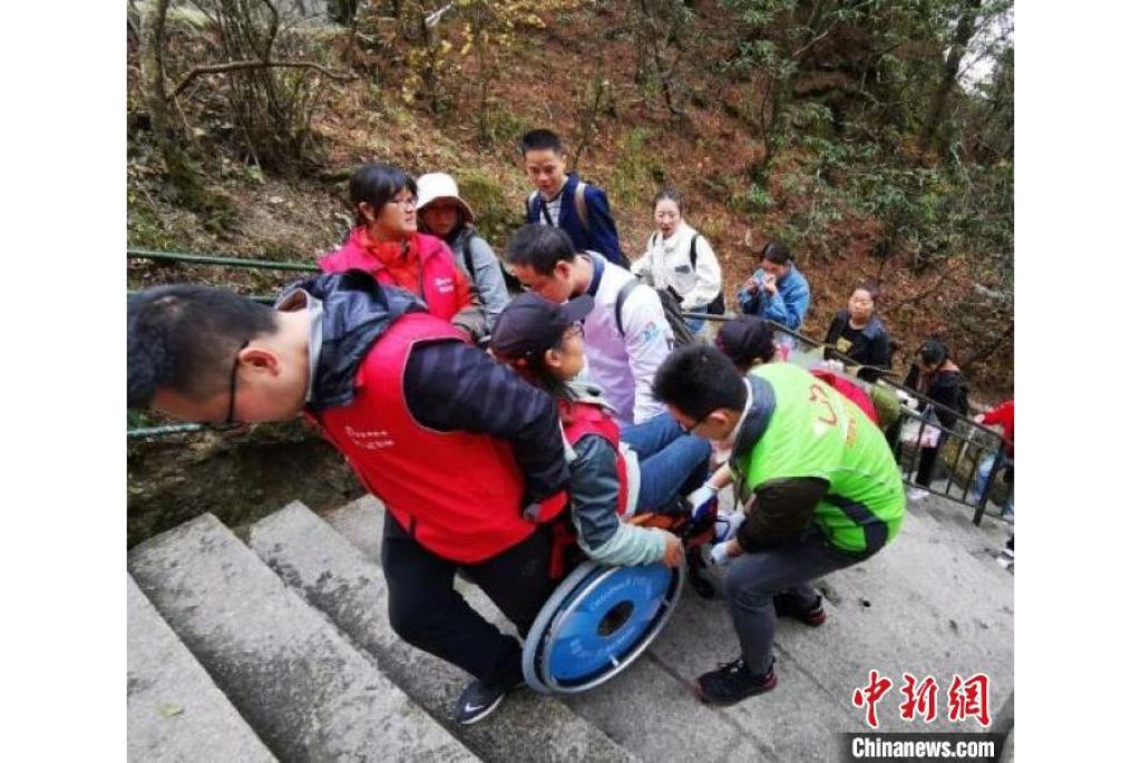 “轮友”在志愿者的帮助下登山