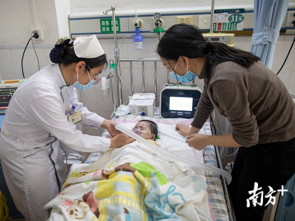 媽媽跟護士學習如何照顧病兒。