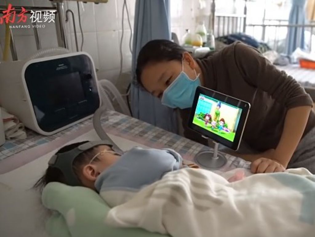 苦中作樂，母子看卡通影片。