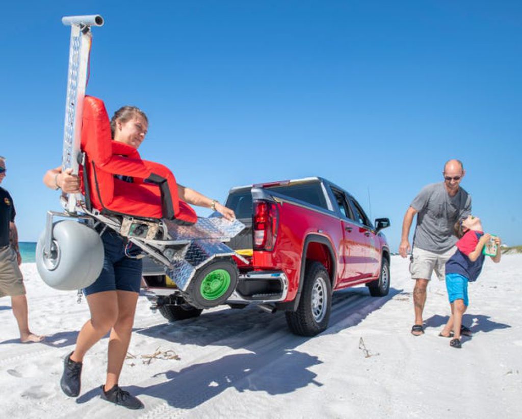 在Navarre Beach上，他的父親Trevor Denton 為11歲的Christian Denton卸下特製的電動輪椅