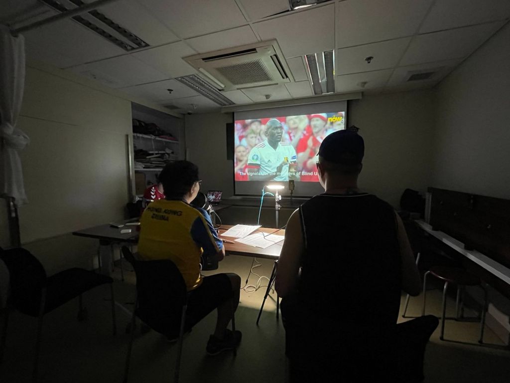 足球评述员李德能及刘舜文，在丹麦对比利时直播中口述赛况。（失明人协进会提供图片）