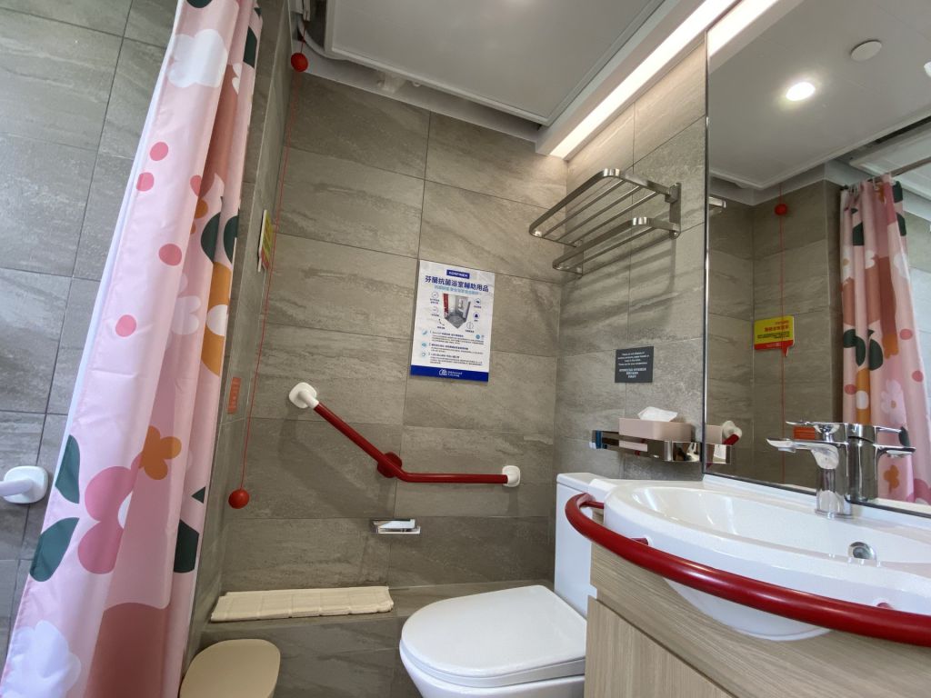 浴室选用了抗菌浴室辅助用品，其设计符合人体工学和防滑，鲜明的暖色设计亦有助认知障碍症患者辨识设备位置，提升整体安全。