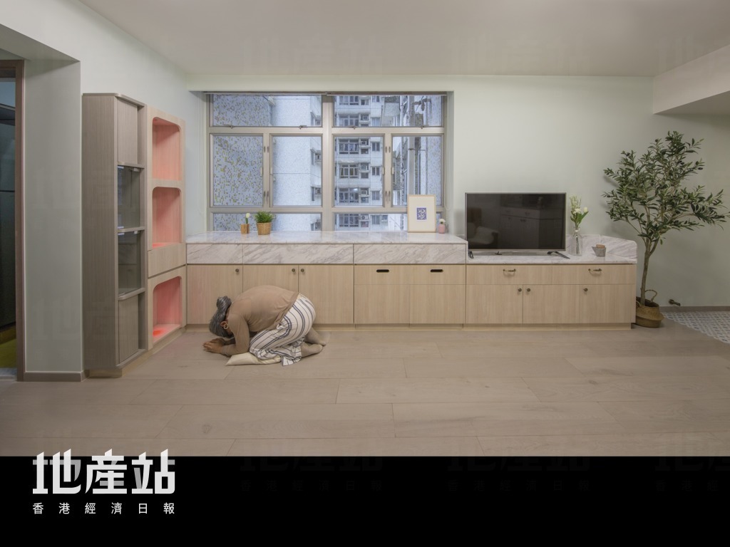 屋主重視傳統祭祀文化，特別要求在窗前訂造一組神櫃。設計師以木紋生態板及紅色LED射燈取代傳統款式，免卻違和感。