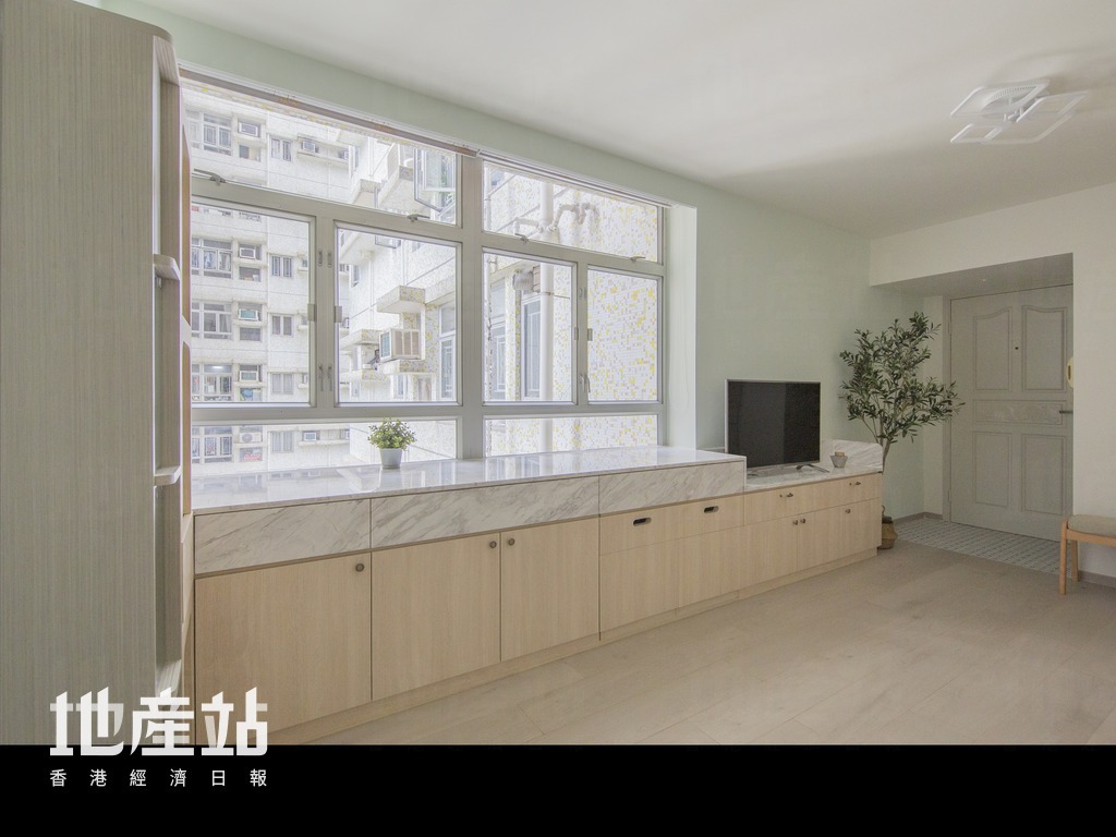 設於大窗前的矮櫃，全長達14呎半，枱面劃一鋪上爵士白雲石，用途廣泛。