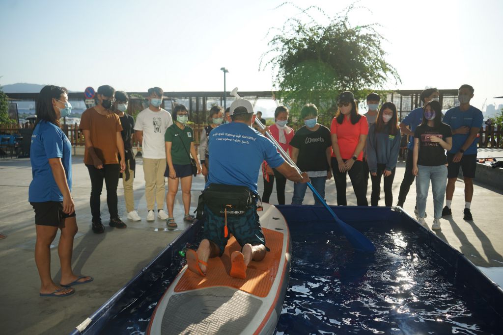 一班視障人士在海風吹拂下，打破身體、地域和天氣的局限，透過水池體驗獨木舟和直立板，享受水上活動帶來的自由和樂趣。