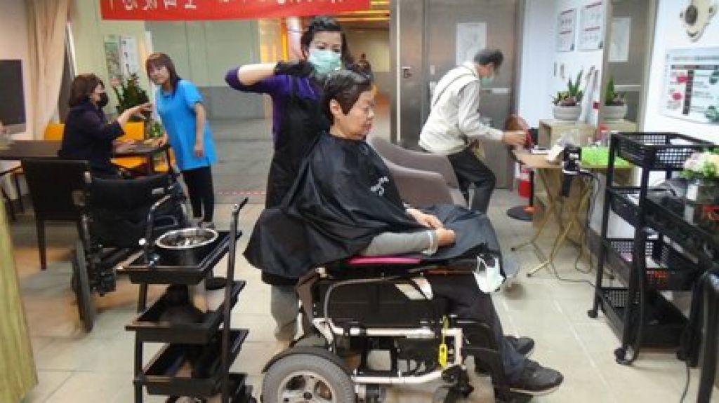 無障礙環境空間讓輪椅族也可輕鬆坐在輪椅上剪染頭髮，圖為姊姊馬晶瀅到店內處理頭髮。